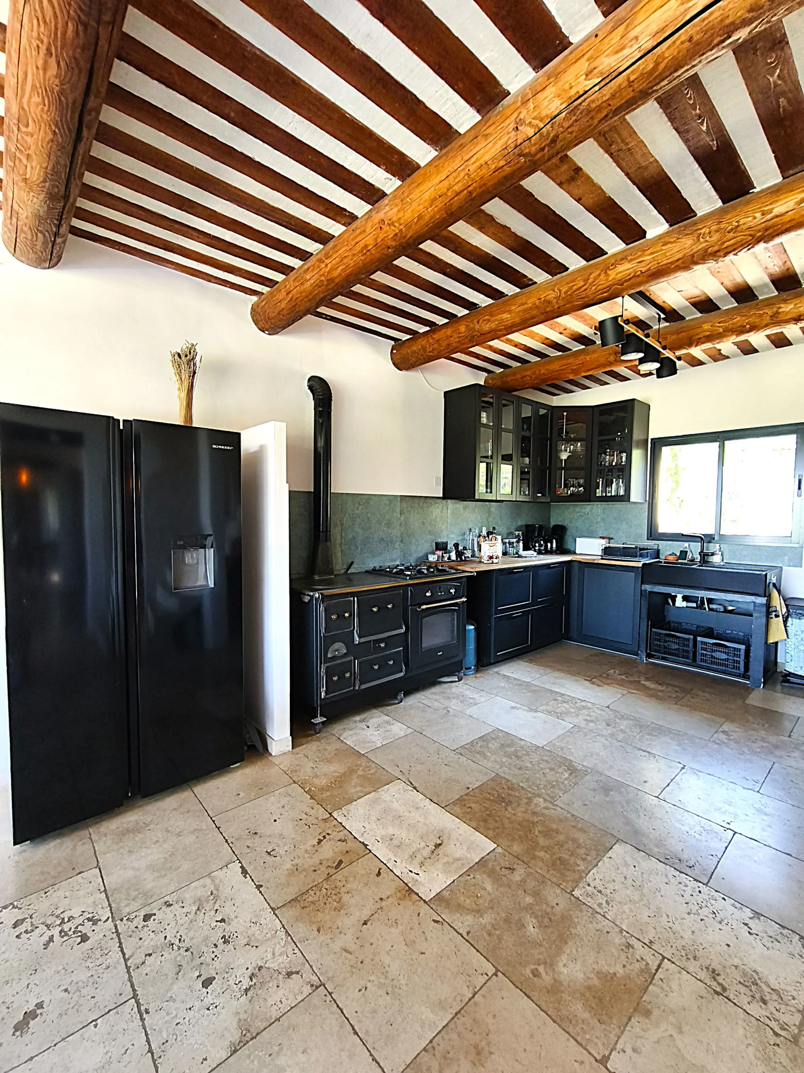 La cuisine entièrement équipée sous son plafond à la provençale