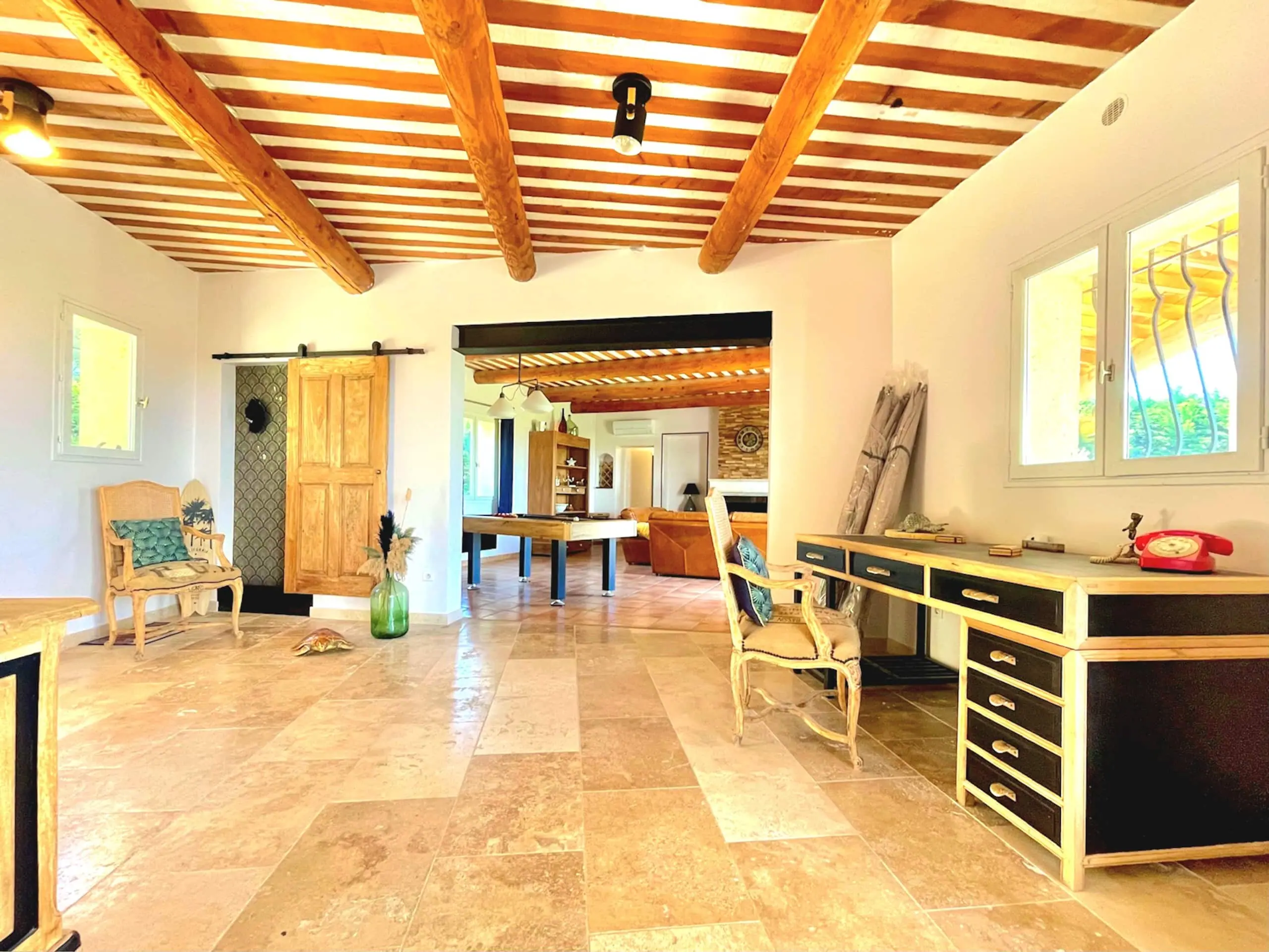 L'entrée de la Villa Roucas ouvrant sur le salon et son plafond à poutres