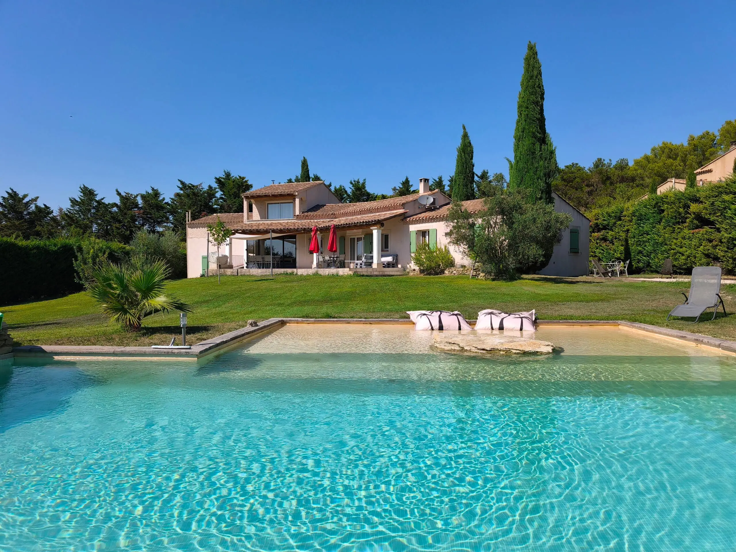 La piscine de la Villa Roucas et la maison entourée de cyprès