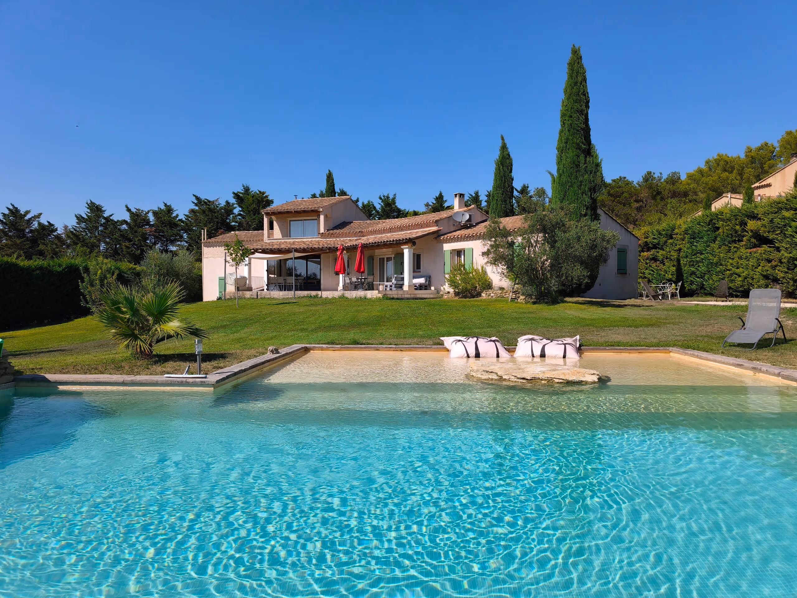La piscine de la Villa Roucas et la maison provençale entourée de cyprès, à L'Isle-sur-la-Sorgue