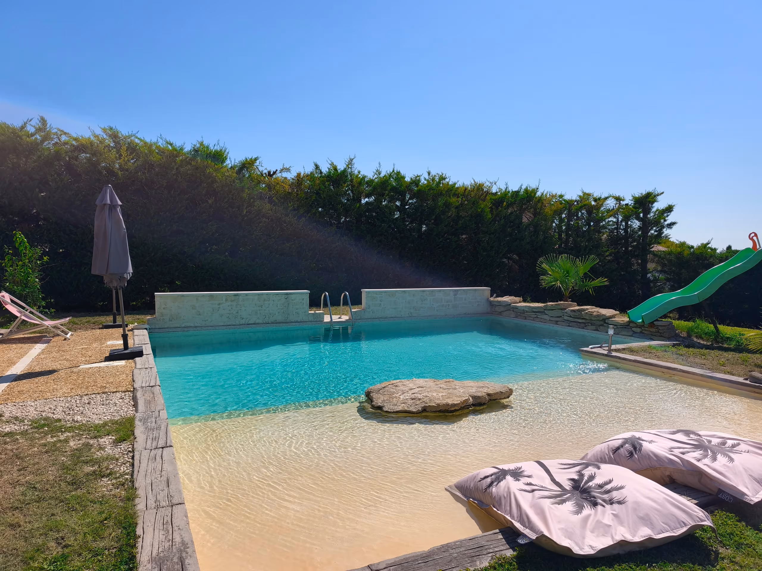 La piscine de la Villa Roucas avec sa plage immergée et son rocher central