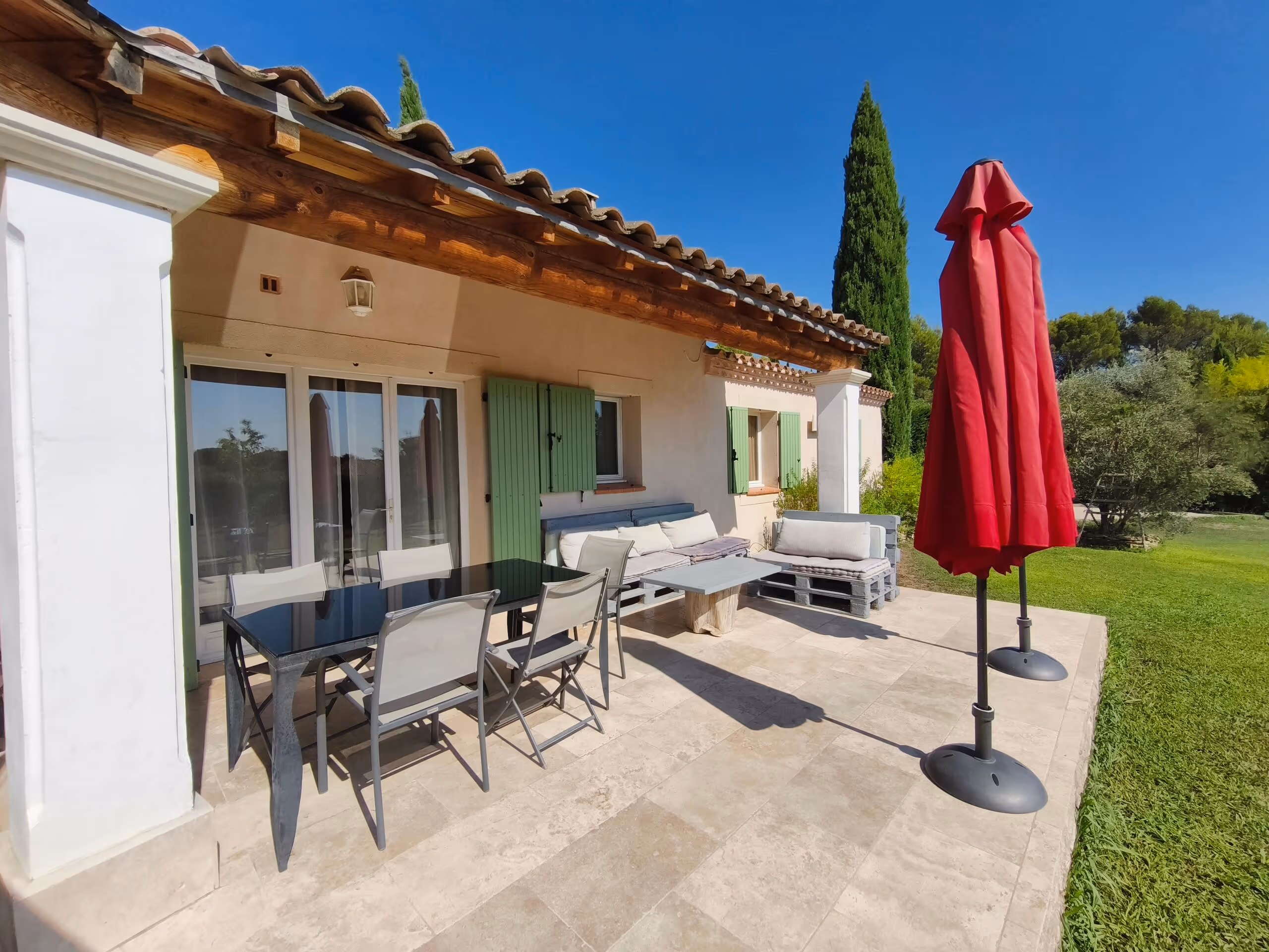 La table dressée sur la terrasse couverte de la Villa Roucas