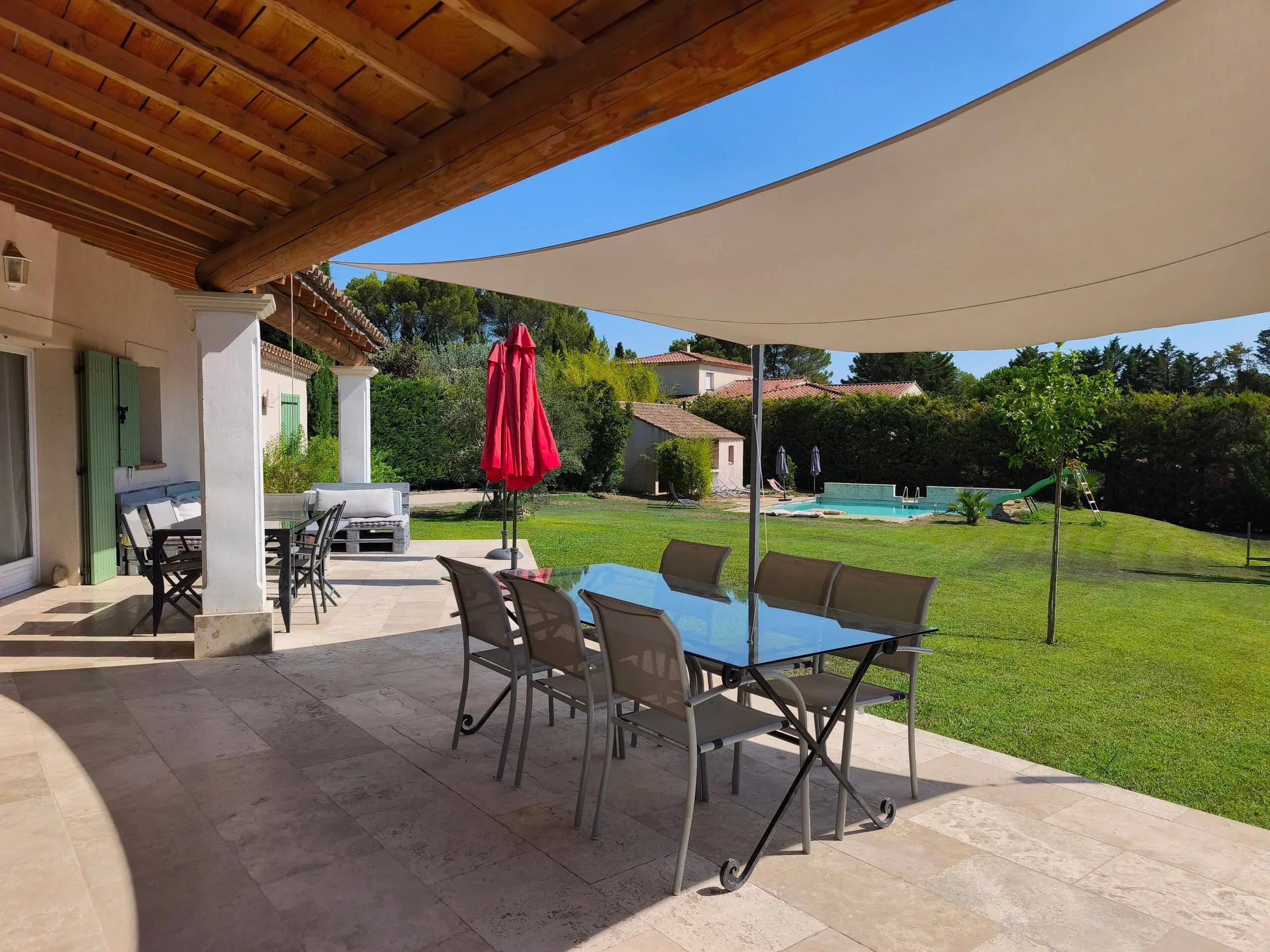 La terrasse couverte et sa voile d'ombrage, table dressée